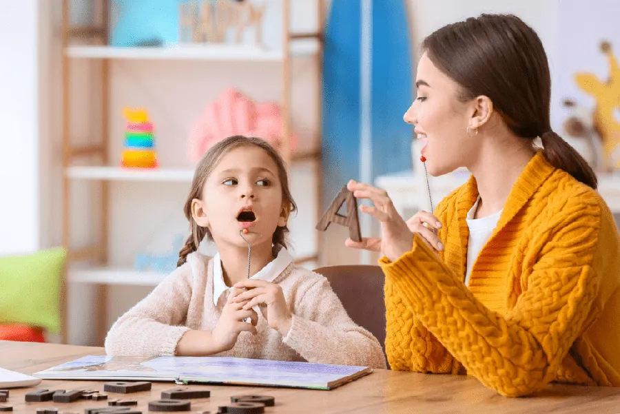 Speech therapist assisting an elderly stroke survivor with oral motor exercises to treat aphasia and swallowing difficulties (dysphagia).